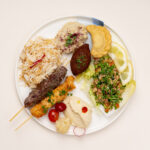 assiette a emporter la cheffe : brochettes de kafta et poulet chich taouk, riz, taboulé, houmous, moutabal, kebbé, sambousik fromage